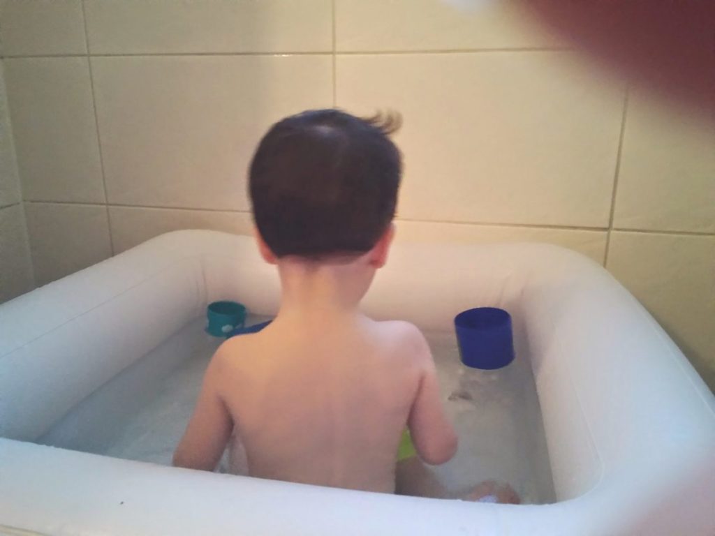 Niño en la bañera hinchable jugando