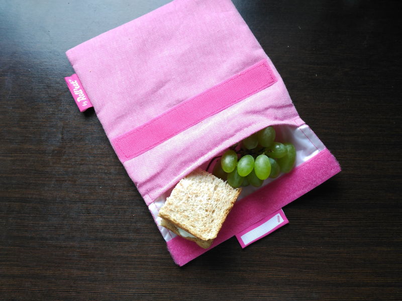 Bolsa de tela para el almuerzo - Bolsa rosa de tela con uvas  y sandwich.