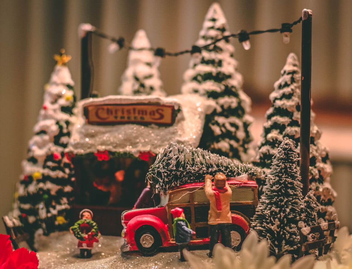 tradiciones navideñas alemania - Imagen ilustrativa - figuras comprando un árbol de navidad en un mercado y subiéndolo al coche