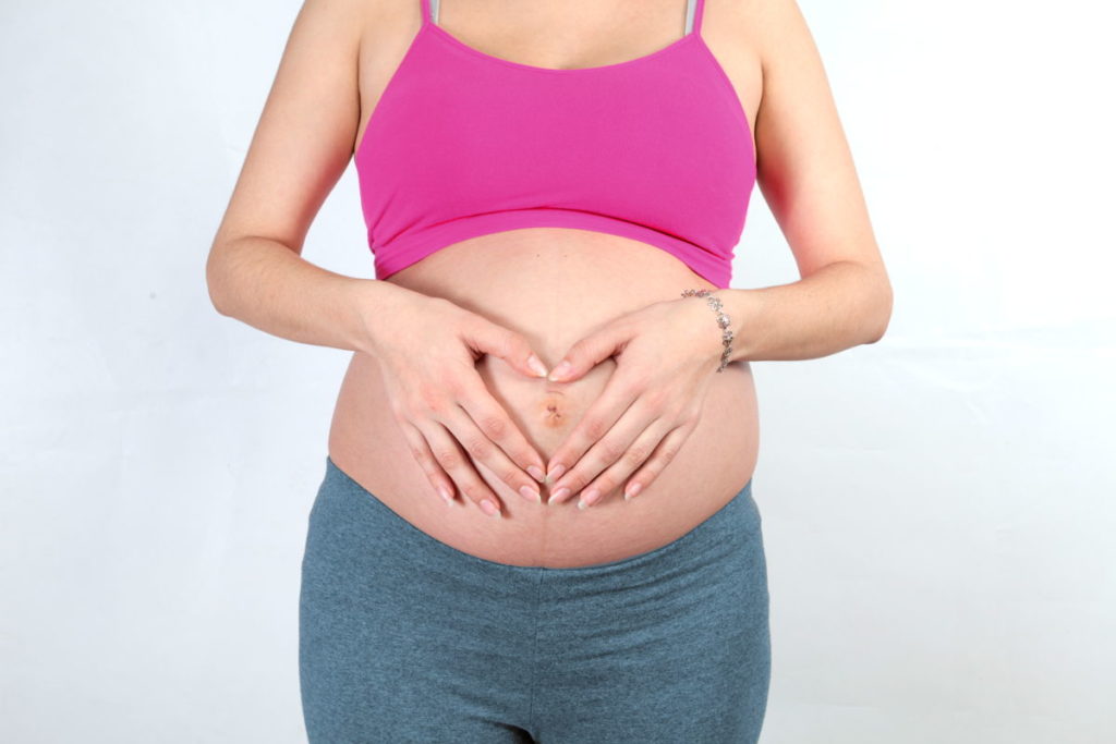 Calculadora de Embarazo de Taisa - Fechas aproximadas de nacimiento del bebé - Imagen ilustrativa embarazada con las manos sobre la barriga formando un corazón.